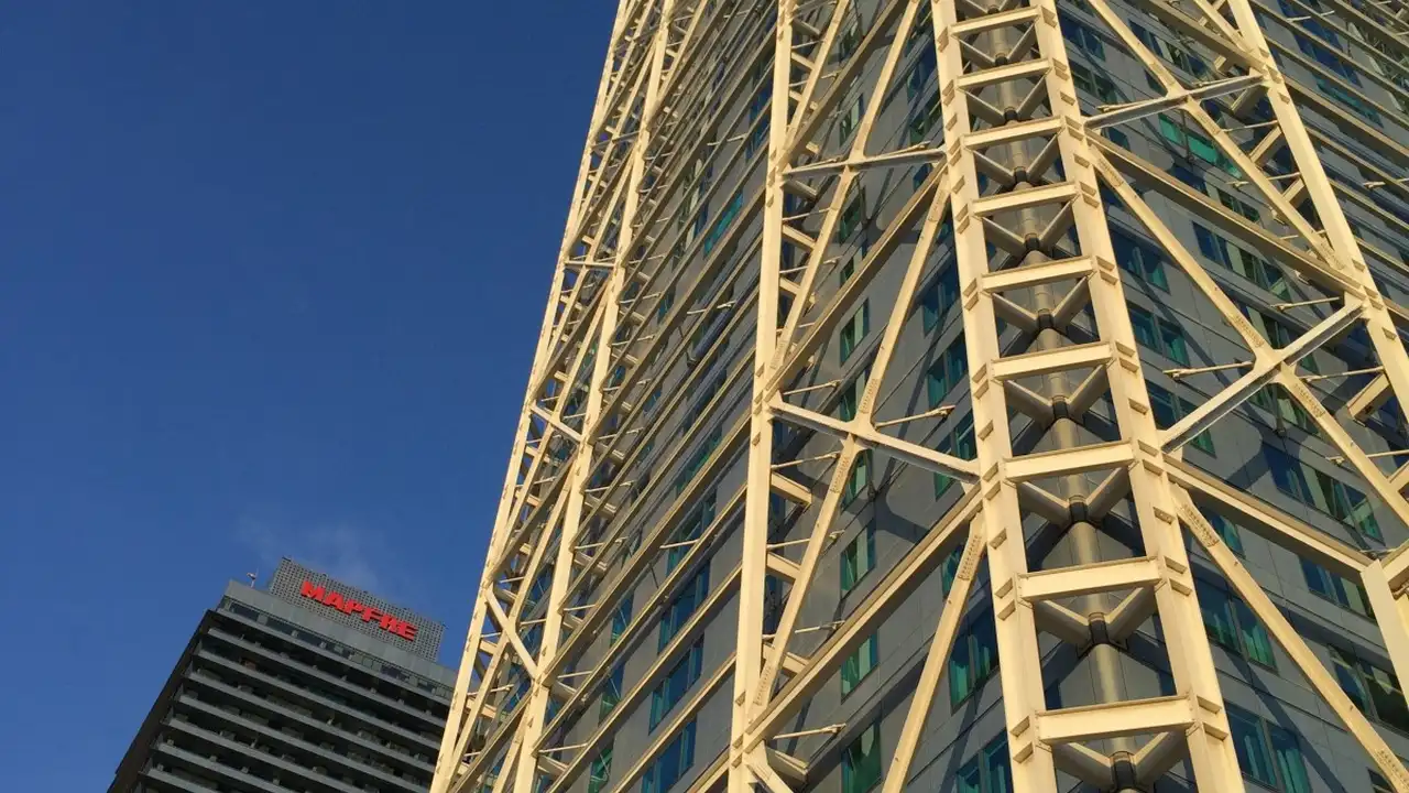 blue bowl of black bean beef tortilla soup on a board with cilantro and shredded cheese in background
